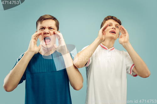 Image of Two young men isolated on blue background