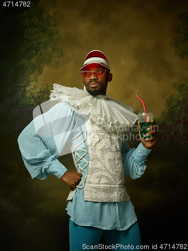 Image of Young man as a medieval knight on dark background