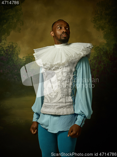 Image of Young man as a medieval knight on dark background