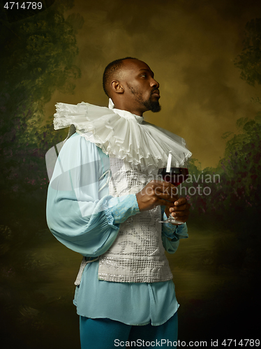 Image of Young man as a medieval knight on dark background