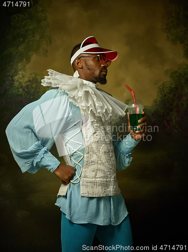 Image of Young man as a medieval knight on dark background