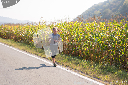 Image of woman jogging along a country road