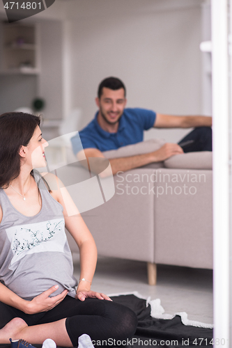 Image of pregnant couple checking a list of things for their unborn baby