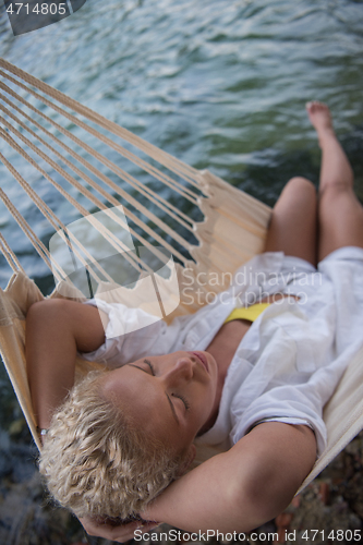 Image of blonde woman resting on hammock