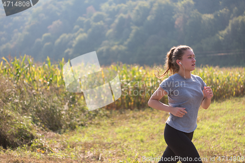 Image of woman jogging along a country road