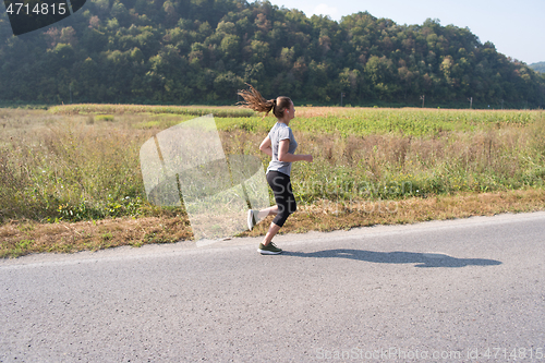 Image of woman jogging along a country road