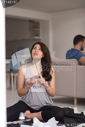 Image of pregnant couple checking a list of things for their unborn baby