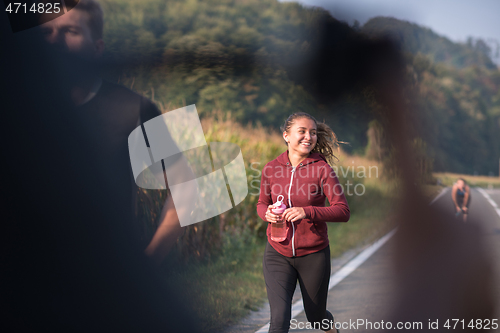 Image of young people jogging on country road