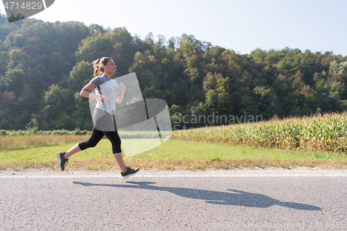 Image of woman jogging along a country road