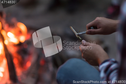 Image of young friends relaxing around campfire