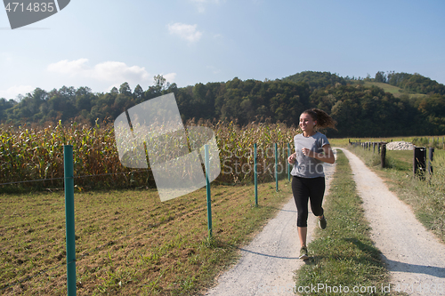 Image of woman jogging along a country road