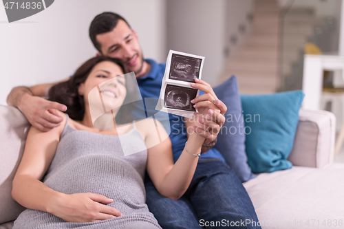 Image of pregnant couple looking baby\'s ultrasound