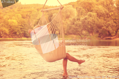 Image of blonde woman resting on hammock