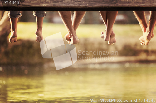 Image of people sitting at wooden bridge