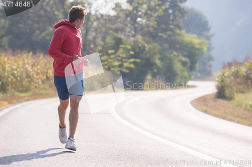 Image of man jogging along a country road