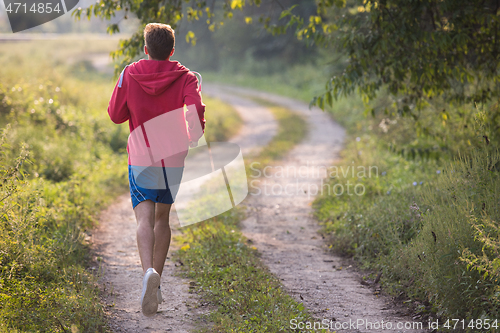 Image of man jogging along a country road