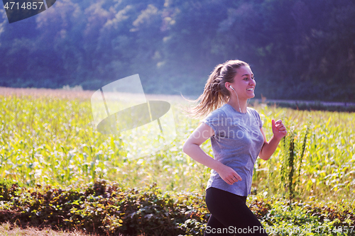 Image of woman jogging along a country road