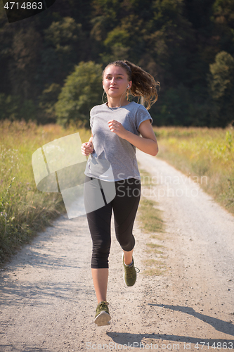 Image of woman jogging along a country road