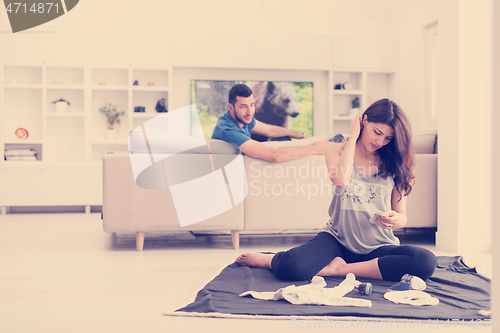 Image of pregnant couple checking a list of things for their unborn baby