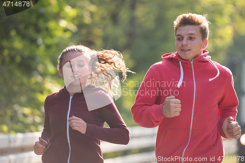 Image of young couple jogging along a country road