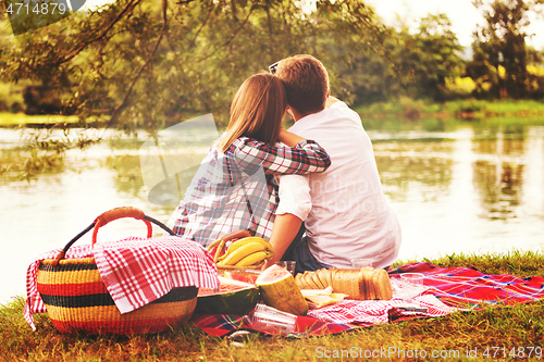 Image of Couple taking a selfie by mobile phone while enjoying picnic tim