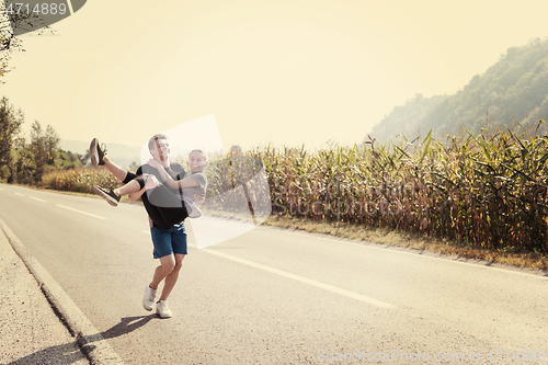 Image of happy couple jogging along a country road