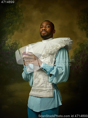 Image of Young man as a medieval knight on dark background