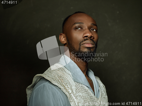 Image of Young man as a medieval knight on dark background