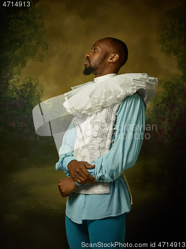 Image of Young man as a medieval knight on dark background