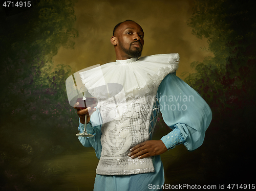 Image of Young man as a medieval knight on dark background