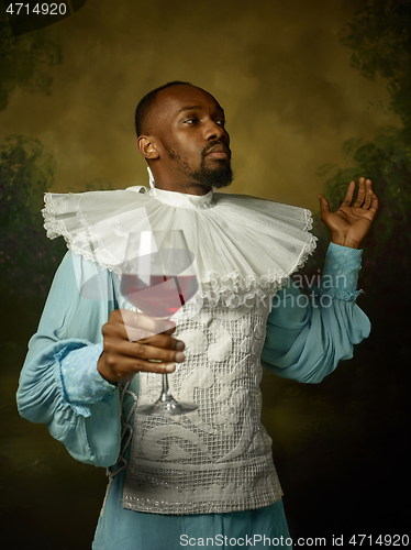 Image of Young man as a medieval knight on dark background