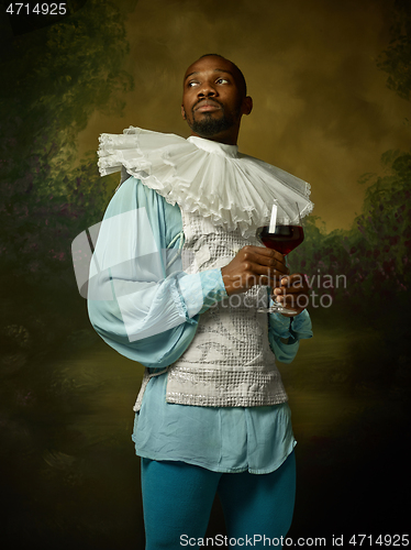 Image of Young man as a medieval knight on dark background