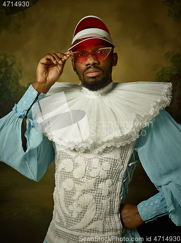 Image of Young man as a medieval knight on dark background