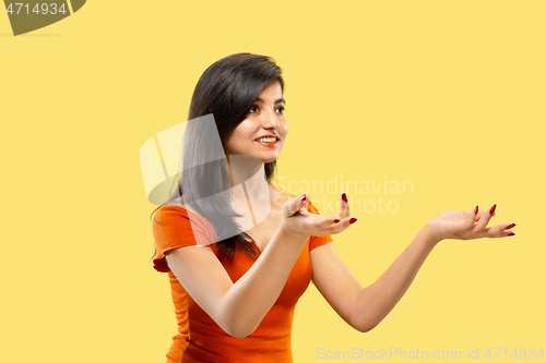 Image of Portrait of beautiful woman isolated on yellow studio background