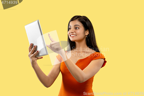 Image of Portrait of beautiful woman isolated on yellow studio background