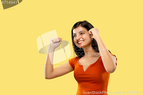 Image of Portrait of beautiful woman isolated on yellow studio background