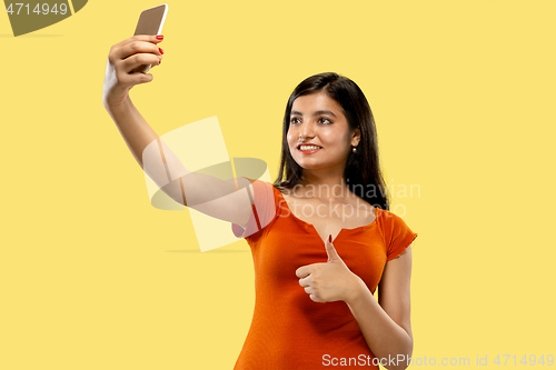 Image of Portrait of beautiful woman isolated on yellow studio background