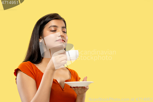 Image of Portrait of beautiful woman isolated on yellow studio background