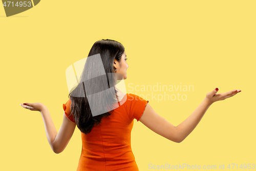 Image of Portrait of beautiful woman isolated on yellow studio background