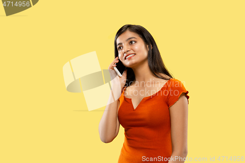 Image of Portrait of beautiful woman isolated on yellow studio background