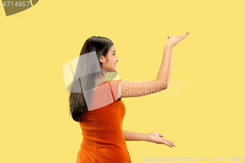 Image of Portrait of beautiful woman isolated on yellow studio background