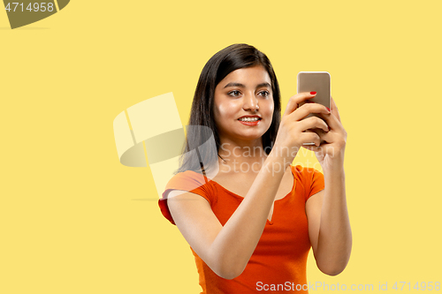 Image of Portrait of beautiful woman isolated on yellow studio background