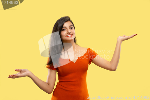 Image of Portrait of beautiful woman isolated on yellow studio background