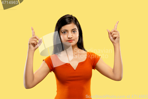 Image of Portrait of beautiful woman isolated on yellow studio background