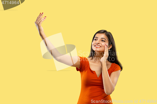 Image of Portrait of beautiful woman isolated on yellow studio background