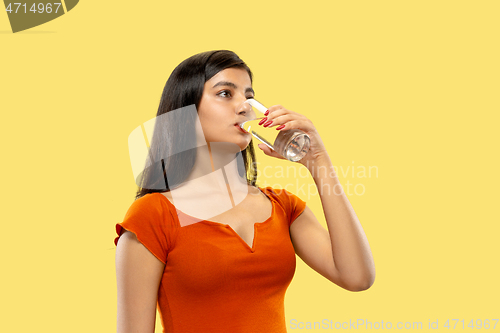 Image of Portrait of beautiful woman isolated on yellow studio background