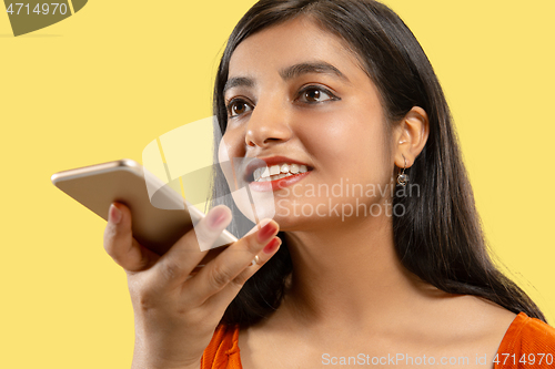 Image of Portrait of beautiful woman isolated on yellow studio background