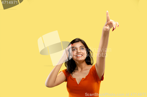 Image of Portrait of beautiful woman isolated on yellow studio background