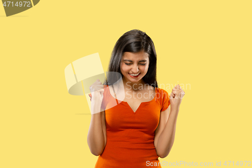 Image of Portrait of beautiful woman isolated on yellow studio background