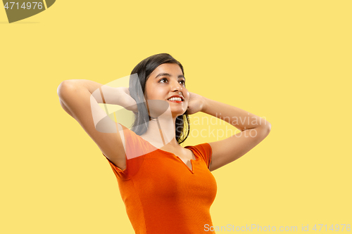 Image of Portrait of beautiful woman isolated on yellow studio background